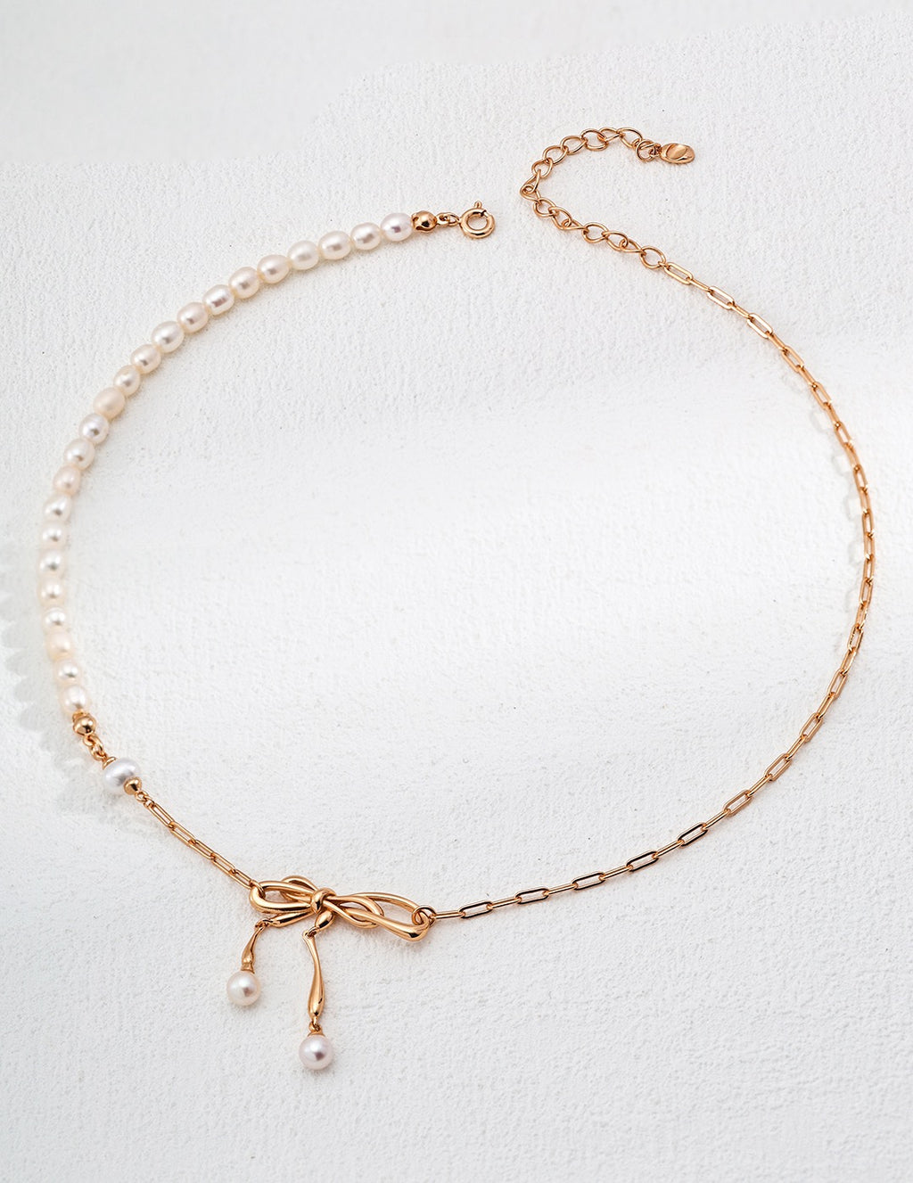 Bow design pearl necklace with 18K gold plated 925 silver chain and natural freshwater pearls on a white background