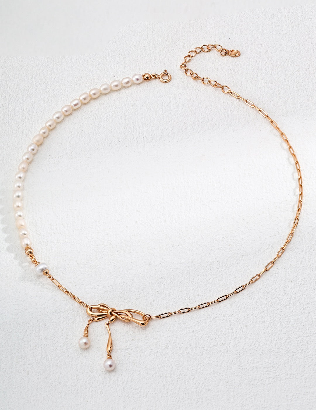 Bow design pearl necklace with 18K gold plated 925 silver chain and natural freshwater pearls on a white background