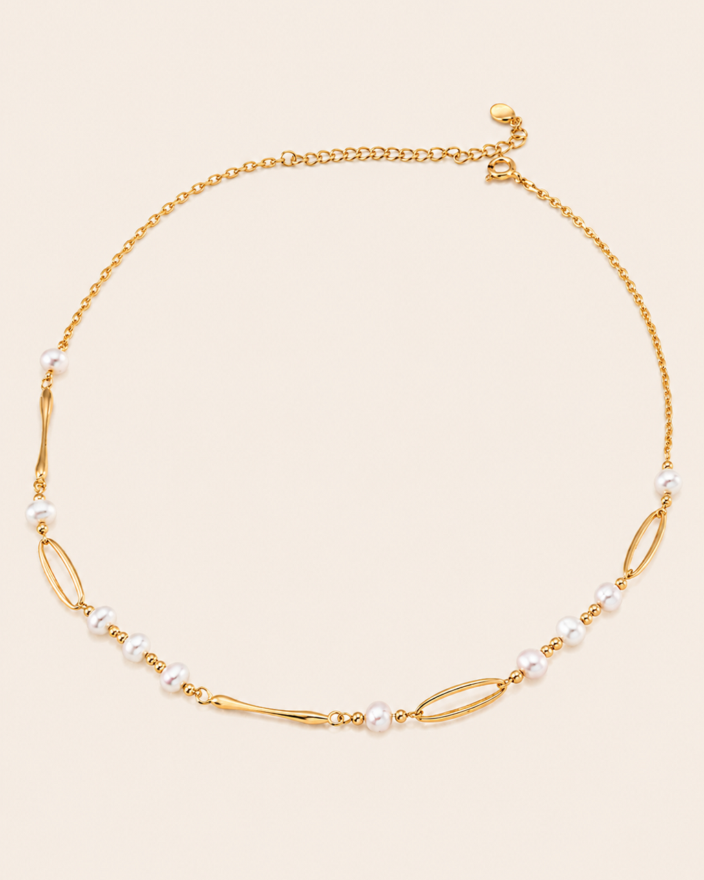 Minimalist gold chain necklace featuring freshwater pearls and elongated link details on a clean ivory background.