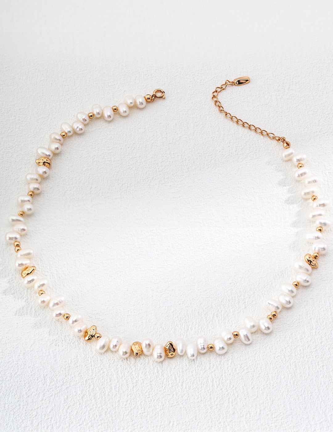 Freshwater baroque pearl necklace with 18K gold plated 925 silver chain on a white background