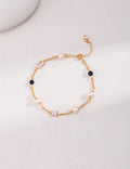 Elegant 18K gold plated bracelet with natural freshwater pearls, black onyx beads, and zircon stones on a white background