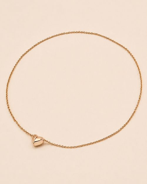 Minimalist magnetic heart necklace in 18K gold-plated sterling silver on a soft ivory background.