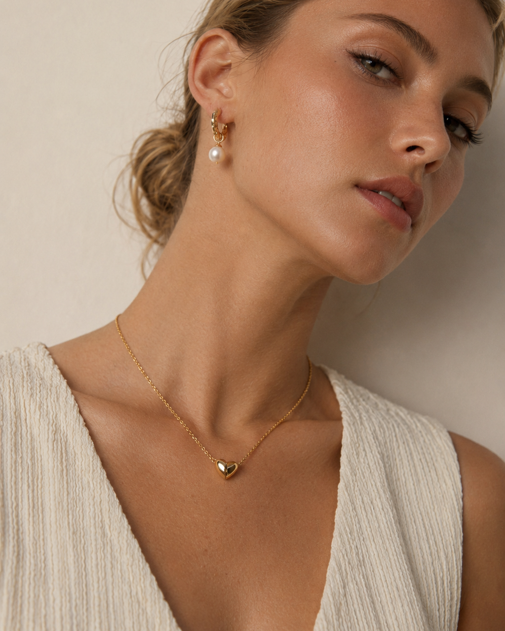 Close-up of a European model wearing a polished magnetic heart necklace in gold-plated sterling silver, highlighting the delicate chain and heart pendant.