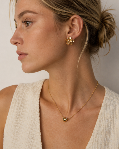 European model wearing a minimalist magnetic heart necklace in 18K gold-plated sterling silver, styled with a cream textured dress.