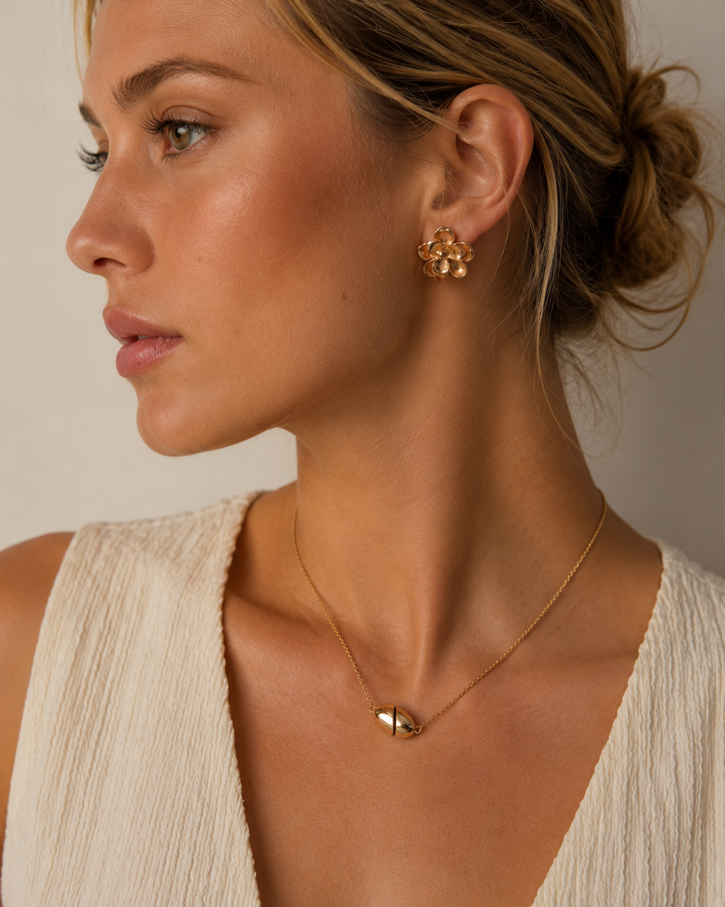 European model wearing a modern oval magnetic necklace in 18K gold-plated sterling silver with a minimalist cream outfit.