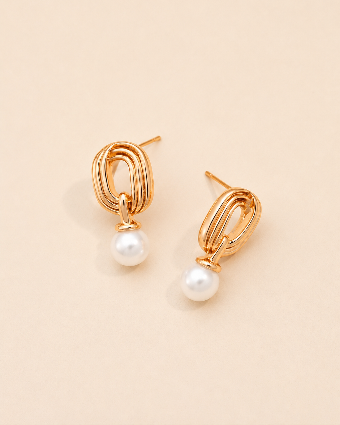 Gold pearl drop earrings crafted from S925 sterling silver with 18K gold plating and natural freshwater pearls, featuring a modern geometric open-link design on a soft cream background.
