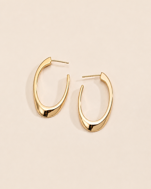 Modern sculptural hoop earrings in 18k gold plated sterling silver with a sleek organic silhouette.