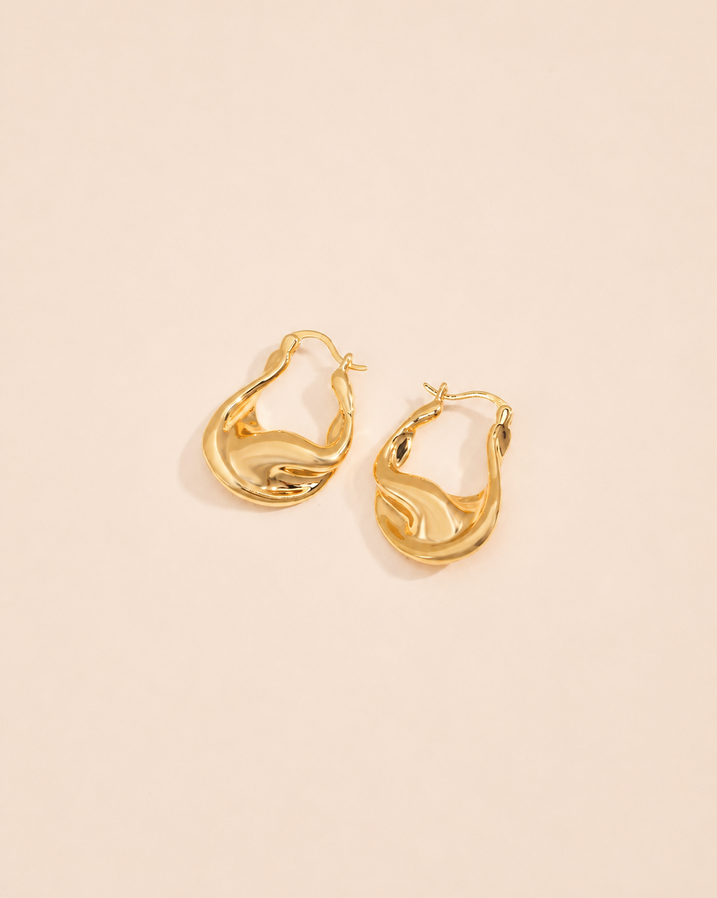 Aurelia twisted sculptural gold hoop earrings in a modern organic design with high-shine gold finish