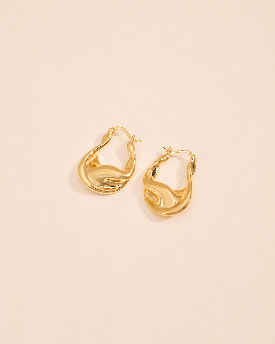 Aurelia twisted sculptural gold hoop earrings in a modern organic design with high-shine gold finish