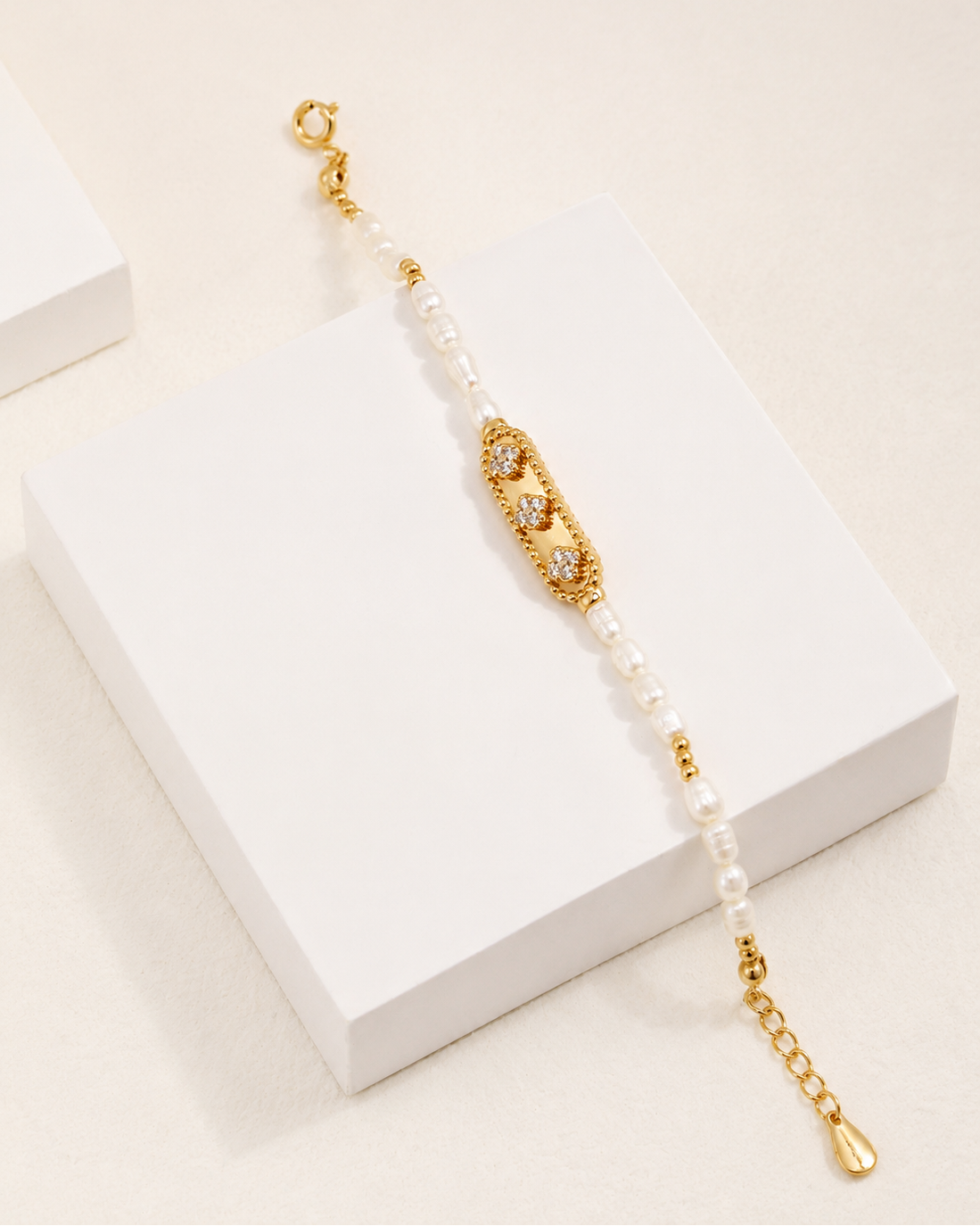 Freshwater pearl and zircon bracelet displayed on a white pedestal, crafted in 18K gold plated sterling silver.