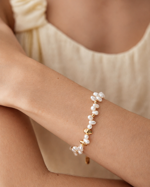 Woman wearing the Aurielle Pearl Bracelet featuring freshwater pearls and organic gold bead accents.