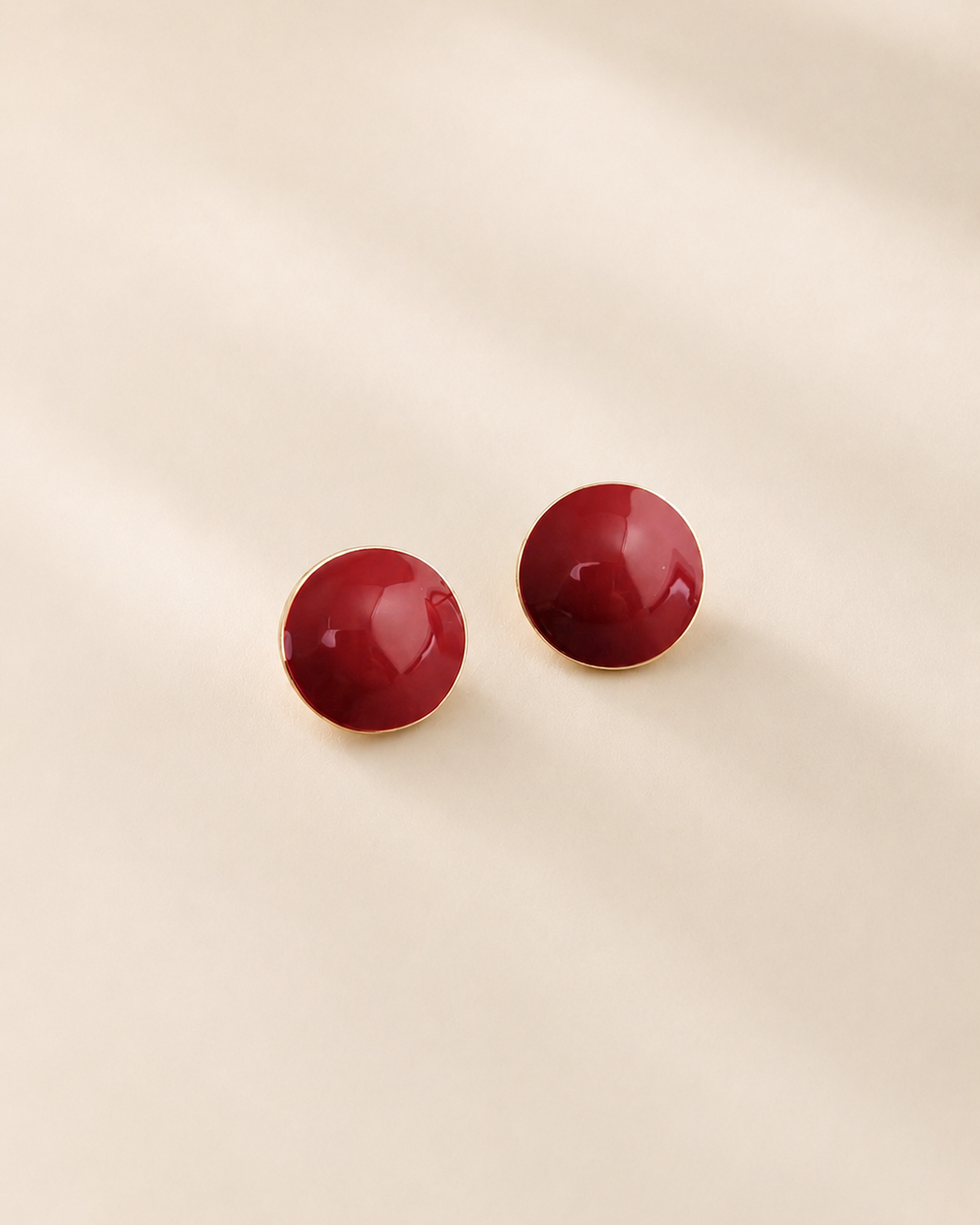 Glossy red enamel stud earrings crafted from S925 sterling silver with thick 18K gold plating, featuring a minimalist round dome design on a soft ivory background.