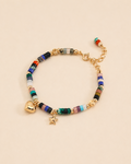 Colorful natural gemstone beaded bracelet with gold heart and star charms in 18K gold plated sterling silver on a soft beige background.