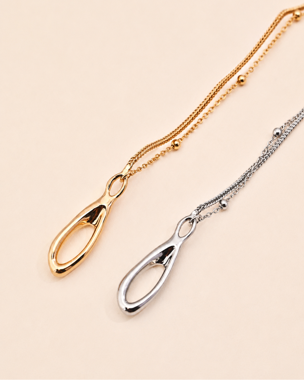 Gold and silver Entwine Branch bracelets featuring organic sculptural clasps and delicate layered chains on a minimalist white background.