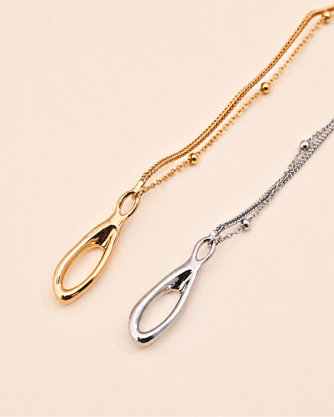Gold and silver Entwine Branch bracelets featuring organic sculptural clasps and delicate layered chains on a minimalist white background.