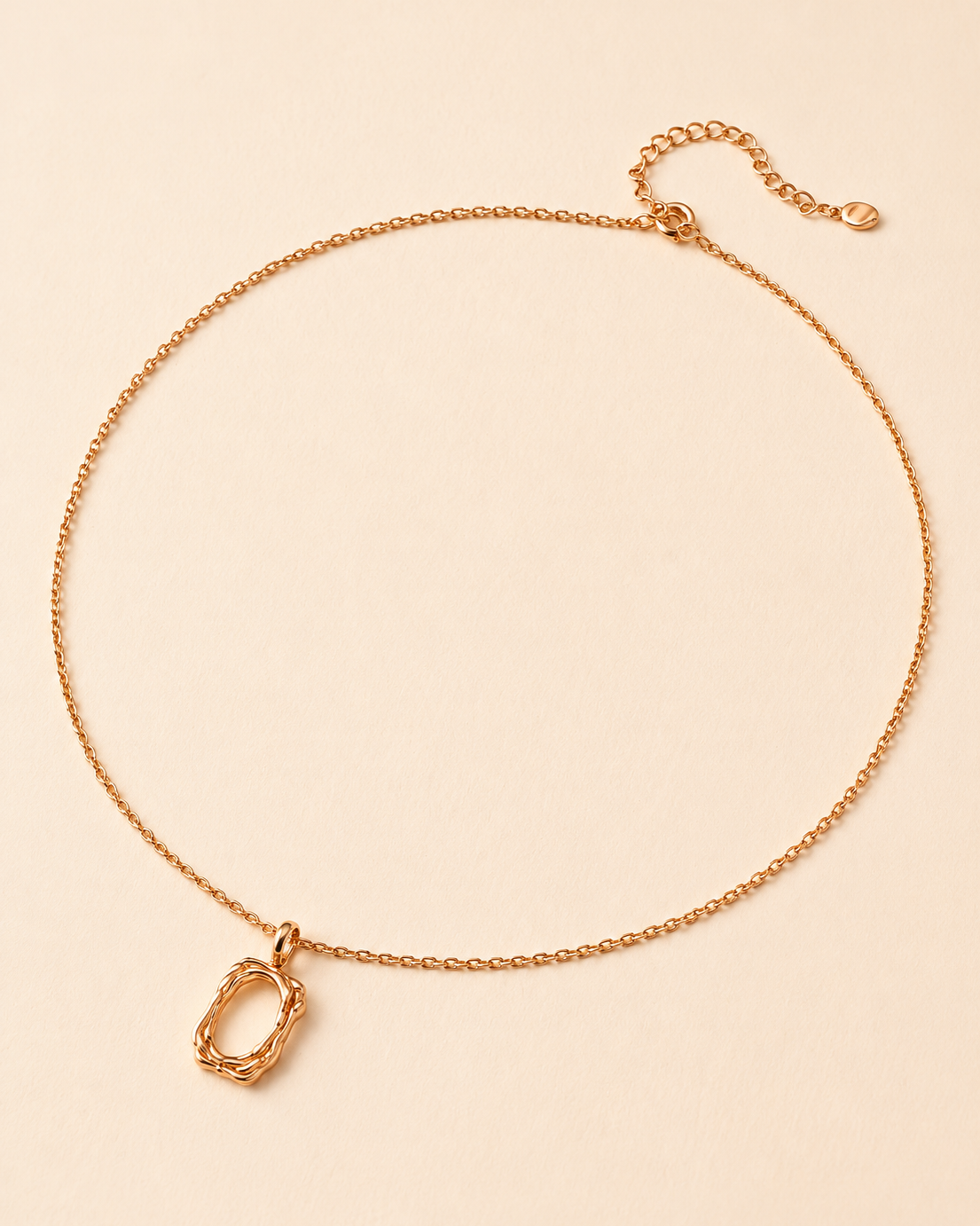18K gold plated sterling silver pendant necklace featuring an organic sculptural open-frame charm on a delicate chain, displayed on a soft beige background.