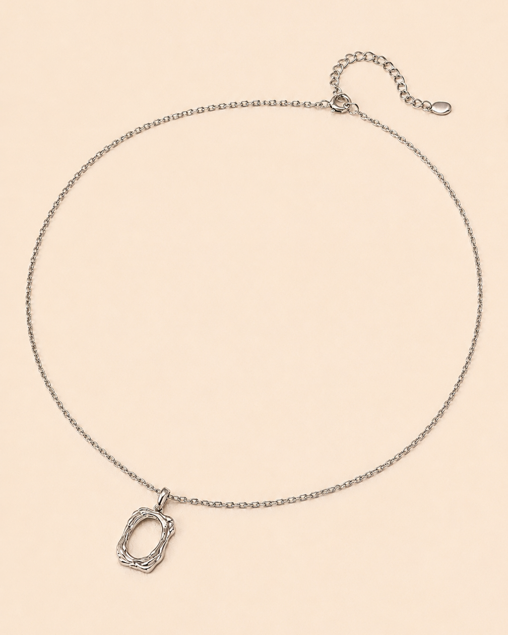 18K white gold plated sterling silver pendant necklace with an organic open-frame pendant, photographed on a minimalist beige background.