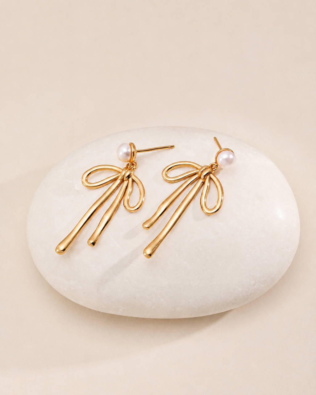 Gold pearl bow drop earrings with delicate ribbon design and pearl studs, elegant feminine jewelry for women.