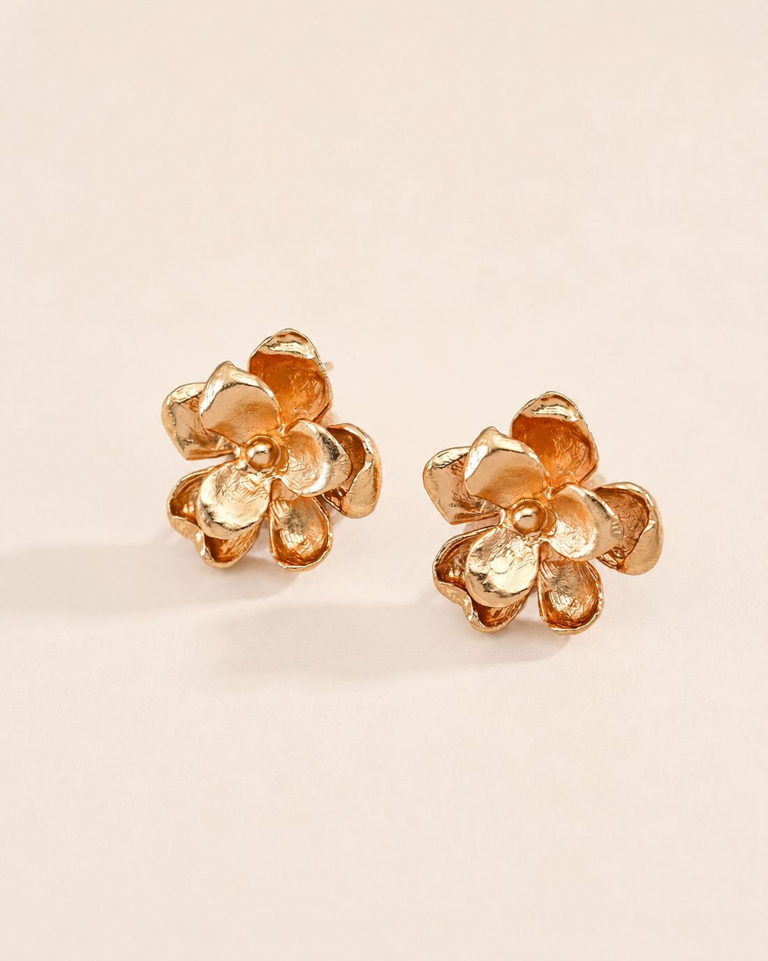Golden Bloom flower stud earrings with sculpted petals and a luminous gold finish, elegant floral jewelry for women.
