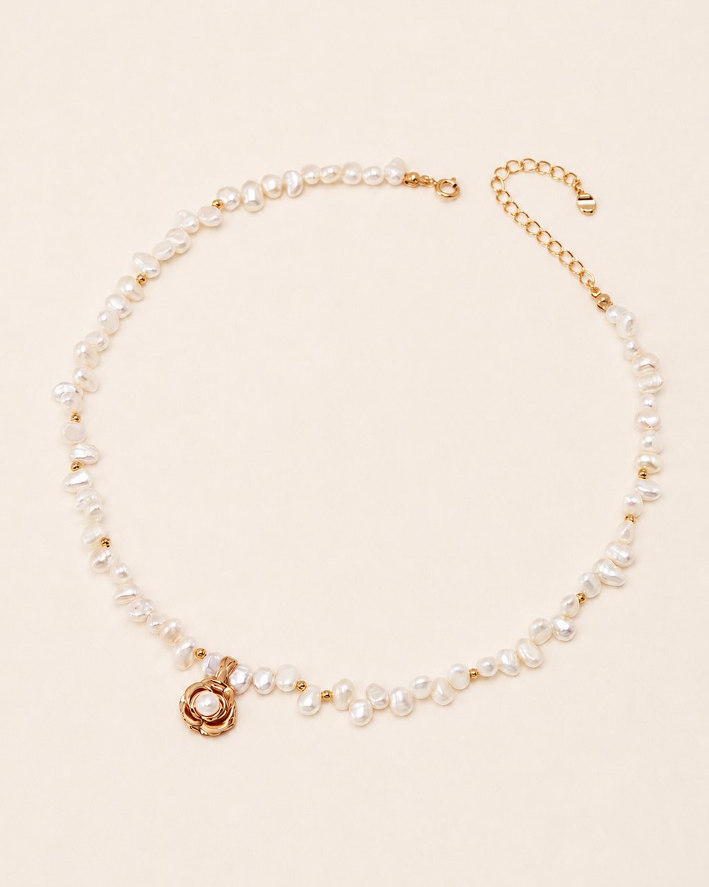 Freshwater pearl necklace featuring a gold camellia flower pendant with a pearl center, displayed on a soft ivory background with an adjustable extension chain.