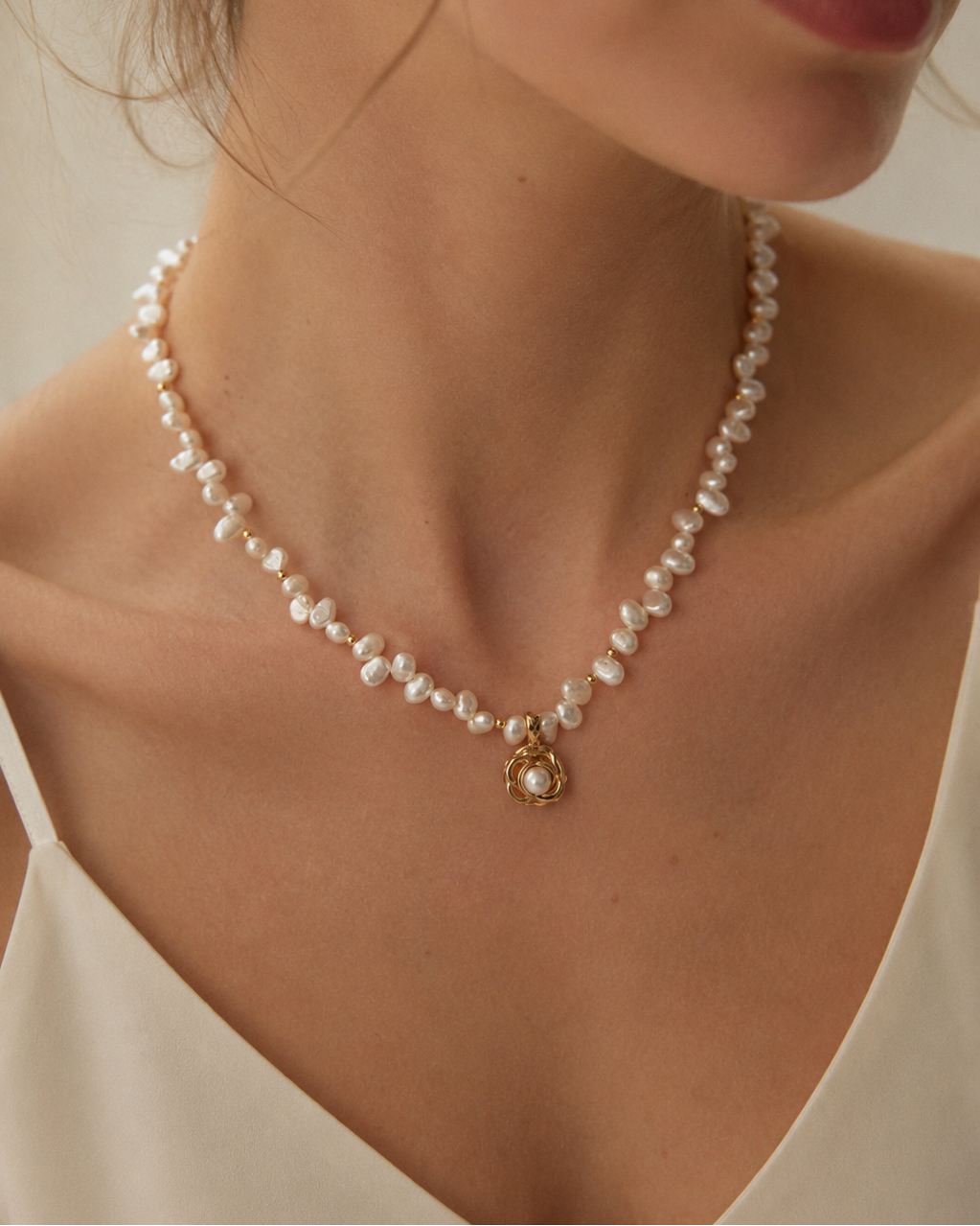 European model wearing a freshwater pearl necklace with a gold nest pearl pendant, elegant bridal and everyday jewelry in 18k gold plated sterling silver