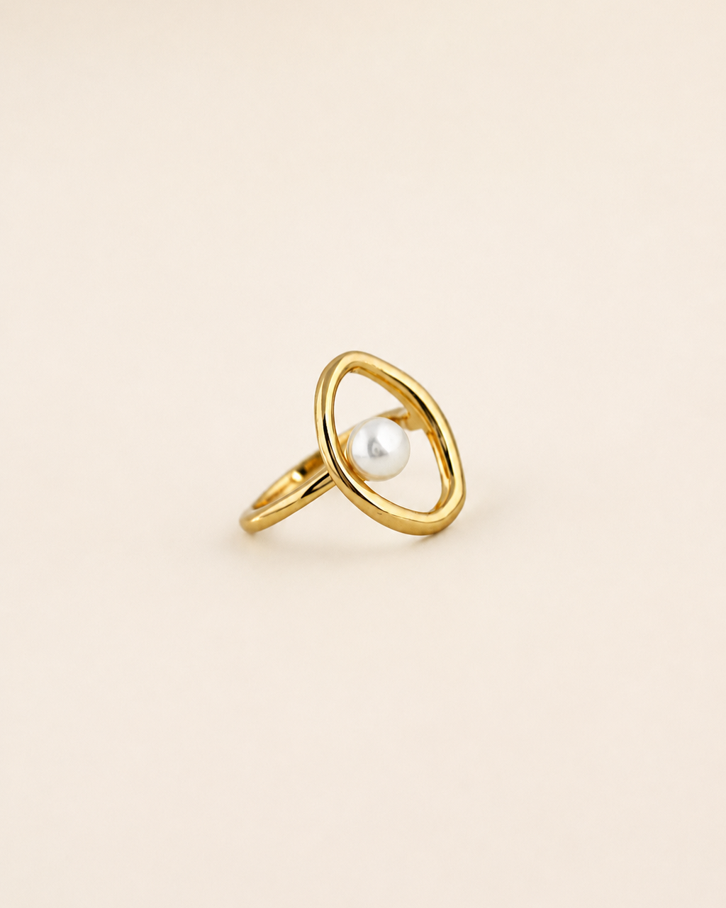 Halo Pearl Ring in 18K gold plated sterling silver with a natural freshwater pearl on a beige background.