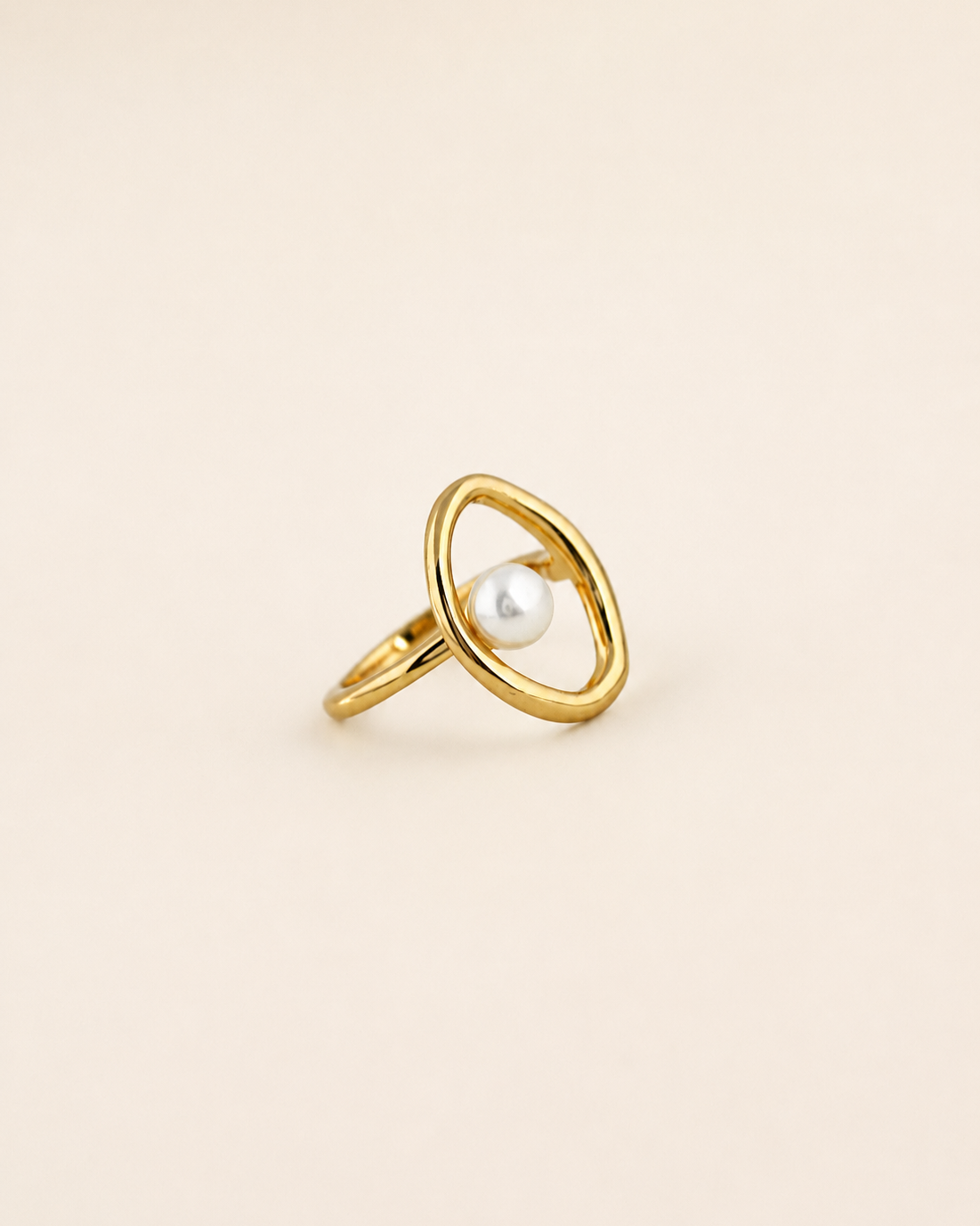 Halo Pearl Ring in 18K gold plated sterling silver with a natural freshwater pearl on a beige background.