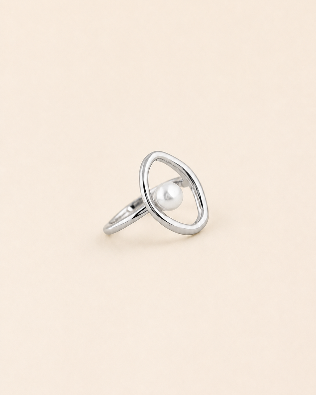 Halo Pearl Ring in white gold plated sterling silver with a natural freshwater pearl on a beige background.