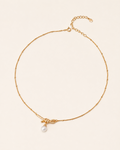 Minimalist gold knot necklace featuring a freshwater pearl pendant on a delicate beaded chain with adjustable length.