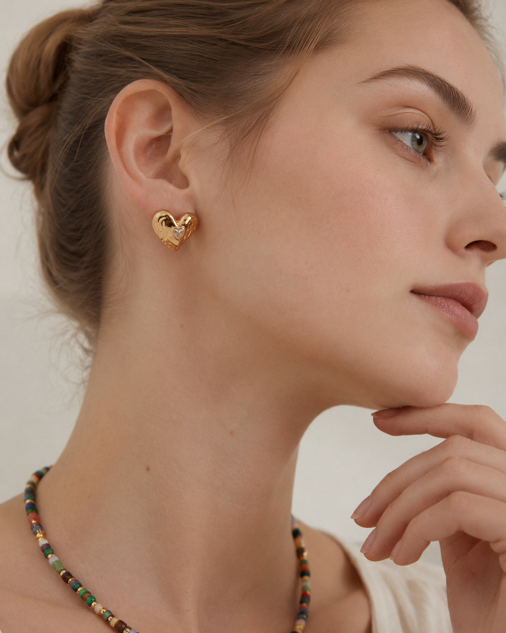 Close-up of Lumi Heart Stud Earrings in thick 18K gold plated S925 sterling silver featuring a sculptural heart design with cubic zirconia.