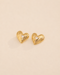 Lumi Heart Stud Earrings in thick 18K gold plated S925 sterling silver with heart-shaped cubic zirconia on a soft ivory background.