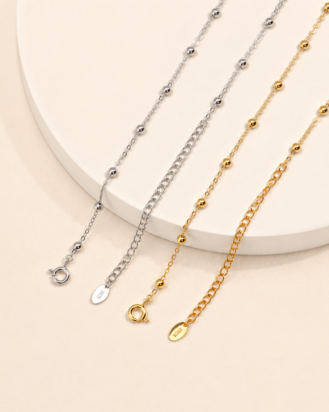 Gold and silver beaded layering necklaces displayed together, showcasing delicate 3mm bead chain design and adjustable extender.