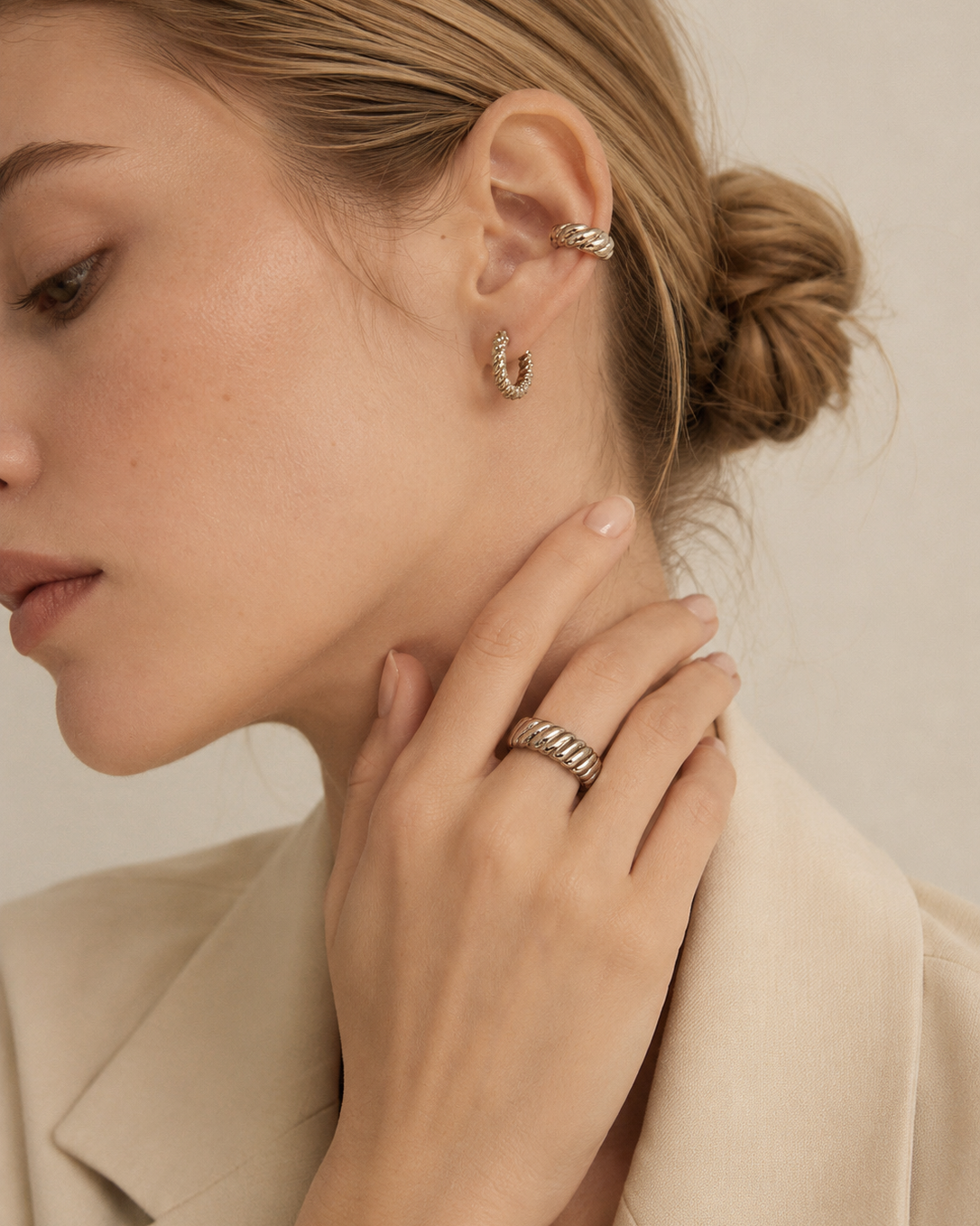 Model wearing an adjustable rope texture ring in thick 18K white gold plated sterling silver with matching hoop earrings.
