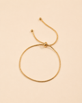 Adjustable gold snake chain bracelet featuring a sleek slider closure and minimalist design.