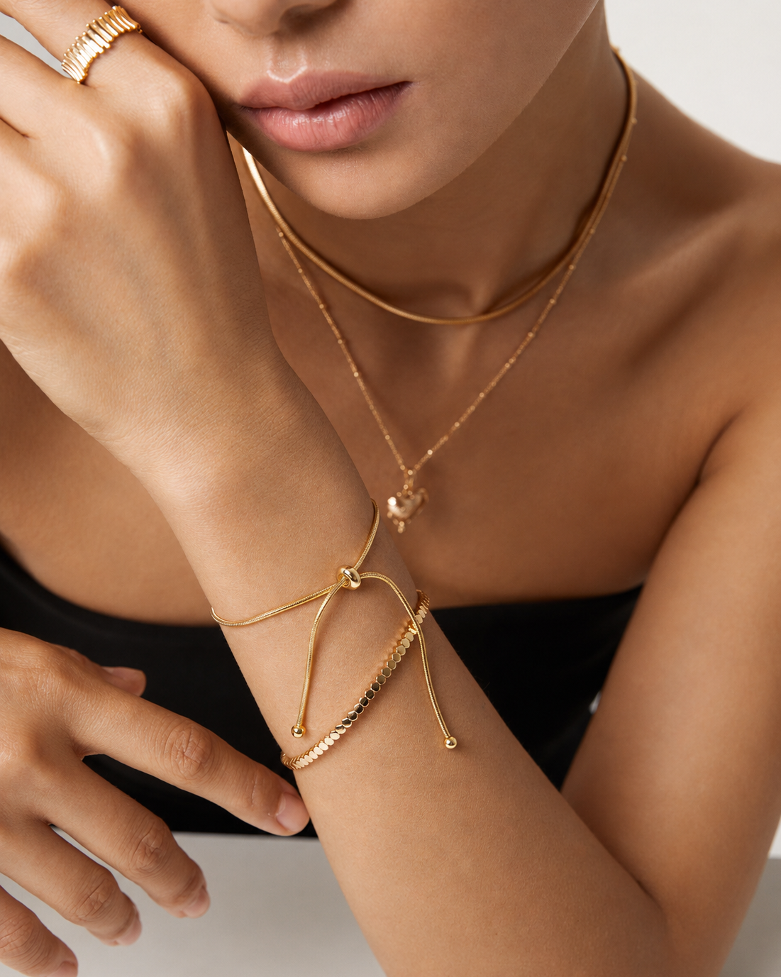Woman wearing the Luna Slider Bracelet, a minimalist adjustable snake chain bracelet in gold.