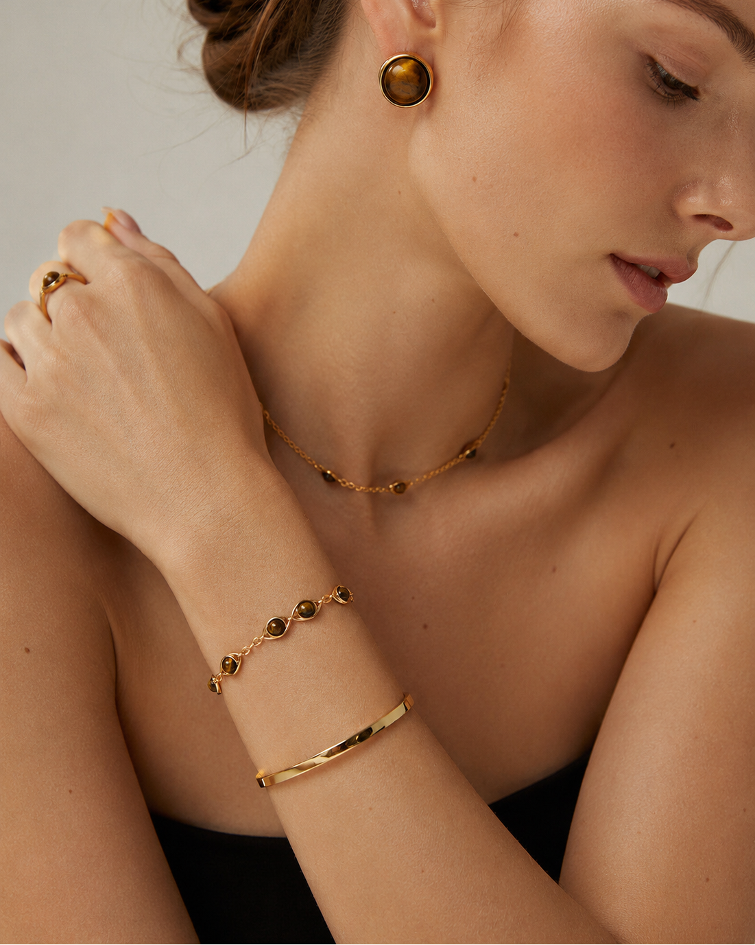Model wearing the Nova Open Cuff in thick 18K gold plated S925 sterling silver styled with matching tiger eye jewelry.