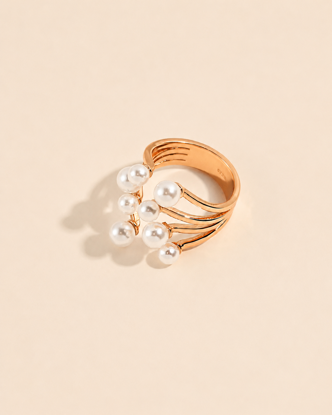 Gold adjustable ring with clustered shell pearls on a soft beige background
