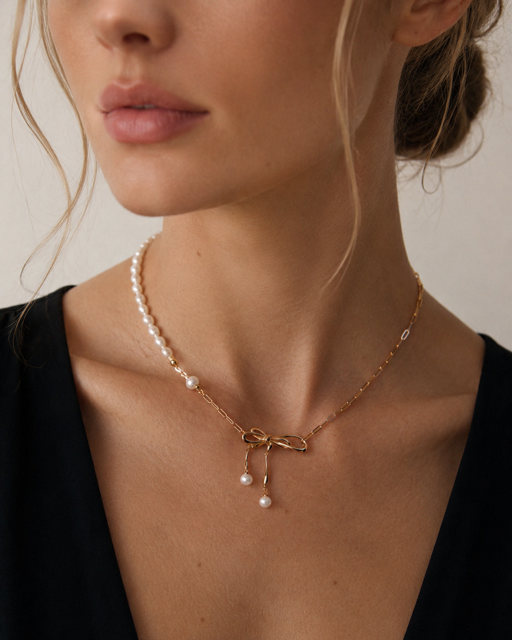 Freshwater pearl bow necklace on a European model, asymmetrical 18k gold plated necklace with pearl drop bow pendant, elegant feminine jewelry for everyday wear.