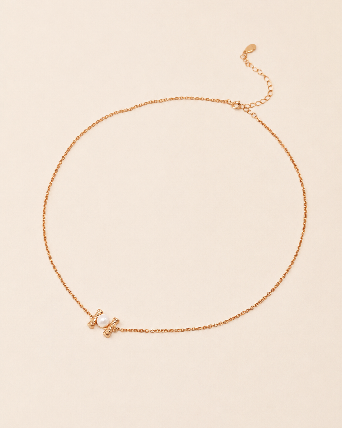 Pearl Whisper Necklace featuring a delicate gold chain with a freshwater pearl accent and adjustable extender chain.