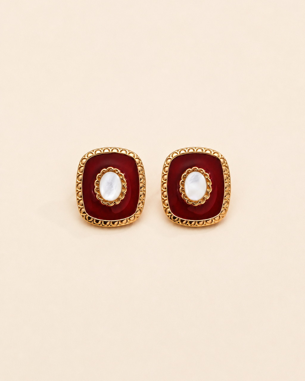 Vintage-inspired red enamel stud earrings with natural shell center and gold-tone detailing, square silhouette on a cream background.