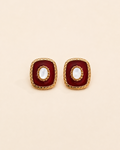 Vintage-inspired red enamel stud earrings with natural shell center and gold-tone detailing, square silhouette on a cream background.