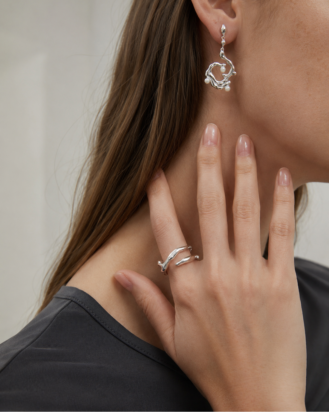 Close-up of a model wearing the Sculpt Flow Ring in 18K white gold plated S925 sterling silver.