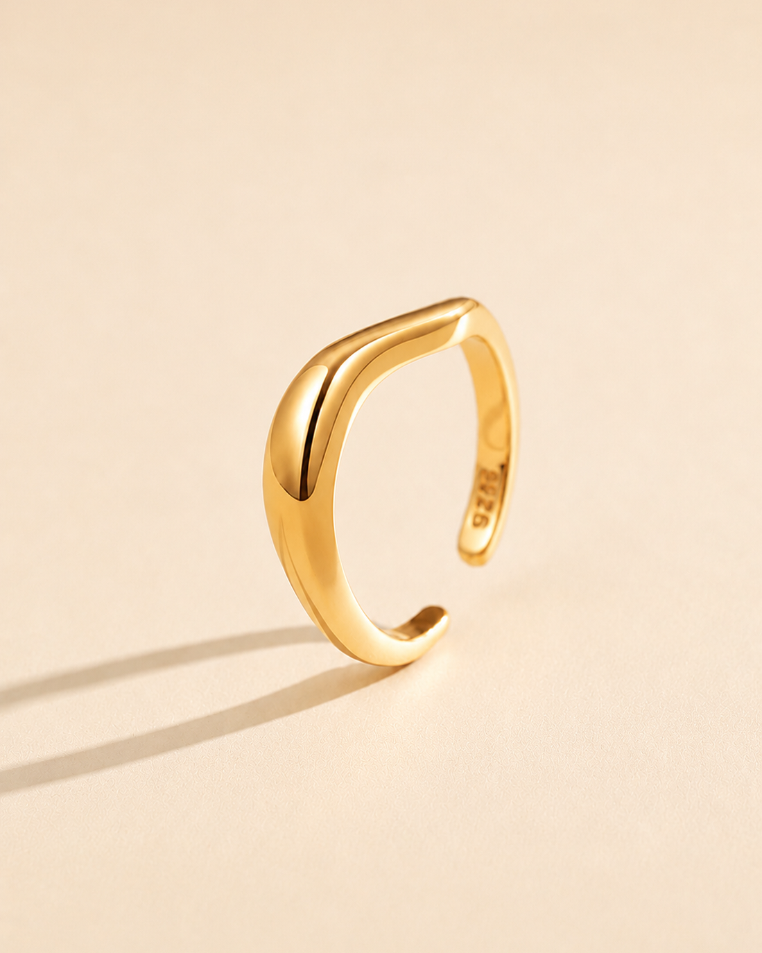 Sculpt Wave adjustable ring in S925 sterling silver with thick 18K gold plating, featuring a polished sculptural curved design on a soft beige background.