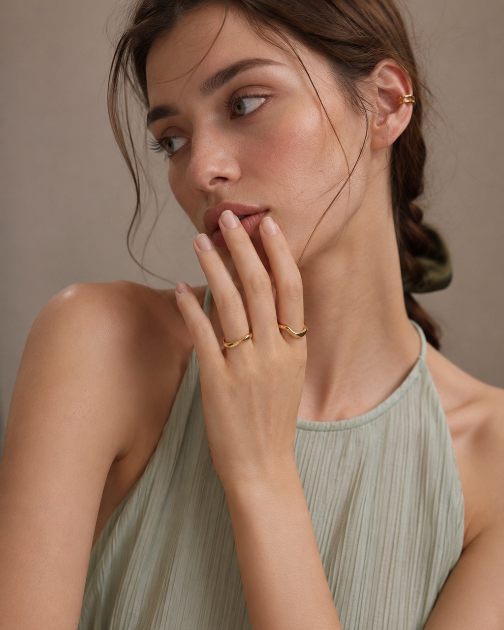 Lifestyle portrait of a model wearing the Sculpt Wave adjustable ring in S925 sterling silver with thick 18K gold plating, featuring an elegant organic curved silhouette.