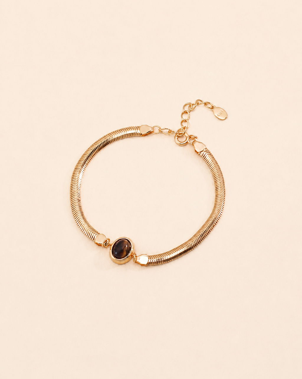 Tiger Eye herringbone bracelet crafted from thick 18K gold plated S925 sterling silver on a soft cream background.