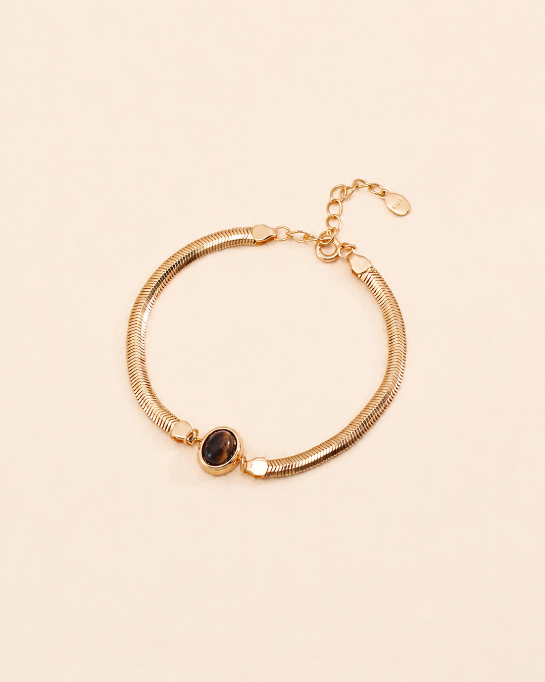 Tiger Eye herringbone bracelet crafted from thick 18K gold plated S925 sterling silver on a soft cream background.