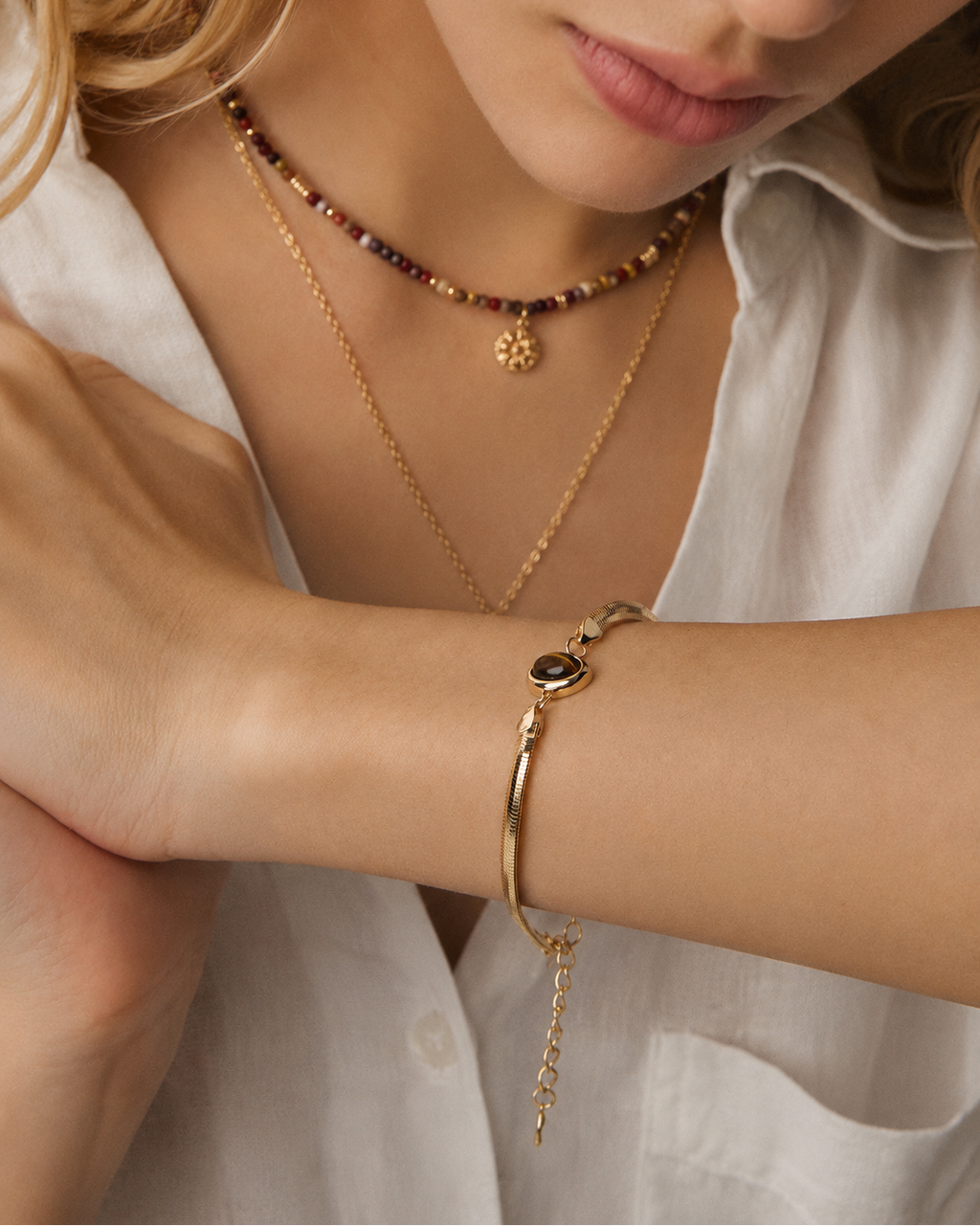 Lifestyle portrait featuring a Tiger Eye herringbone bracelet crafted from thick 18K gold plated S925 sterling silver.