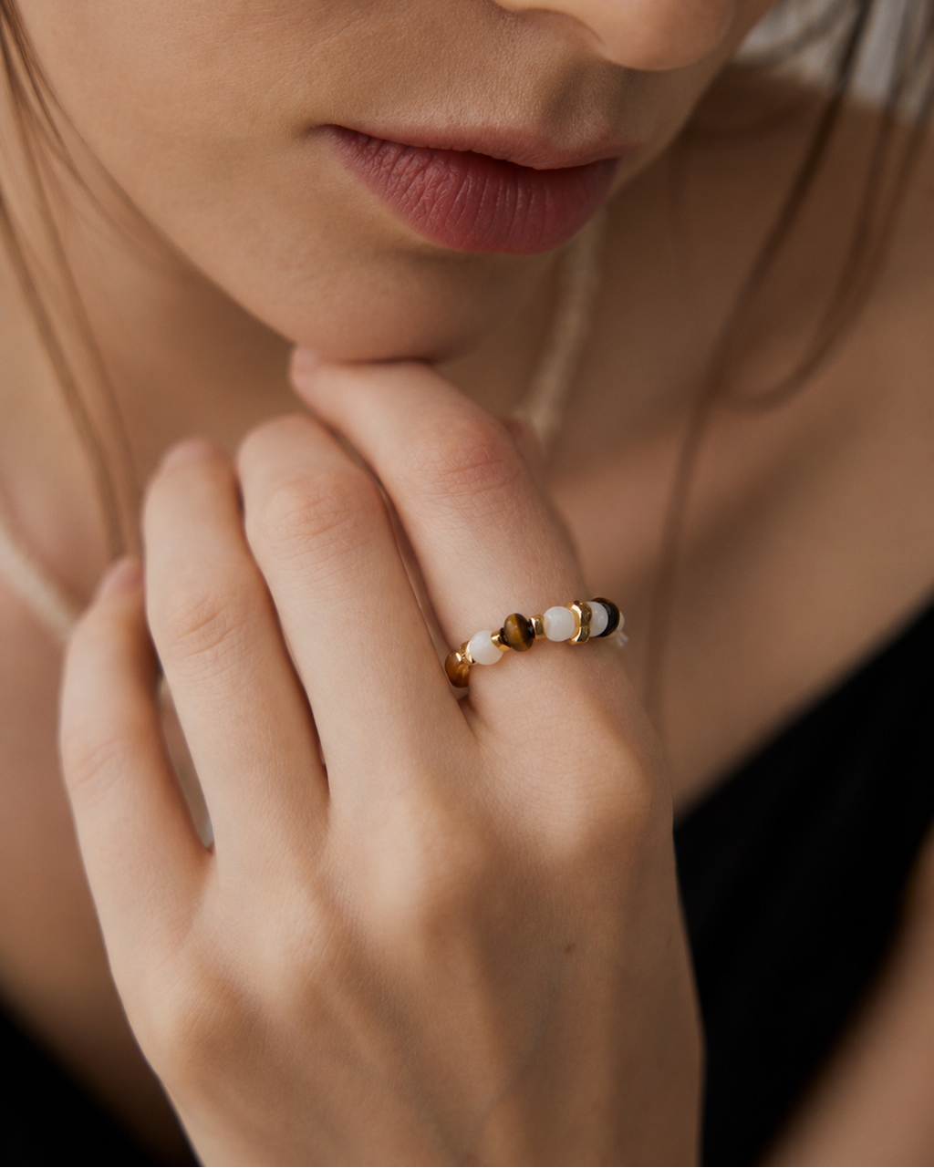 Close-up of a woman wearing a Tiger Eye and Mother of Pearl beaded ring crafted in thick 18K gold plated S925 sterling silver.