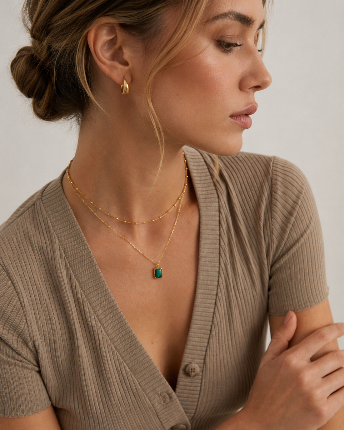 Woman wearing a delicate gold beaded necklace, styled alone for a minimalist everyday jewelry look.