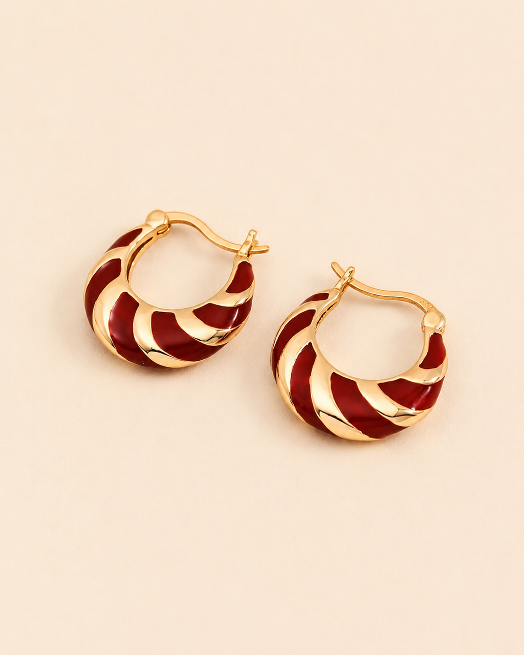 Red enamel hoop earrings crafted in S925 sterling silver with thick 18K gold plating, displayed on a soft ivory background.